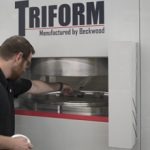beckwood engineer placing a part to be formed in a triform specialty machine